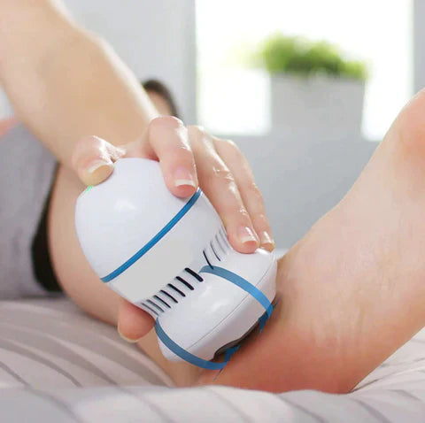A person is using a white vacuum callus remover on their foot, demonstrating how it is used to remove calluses.